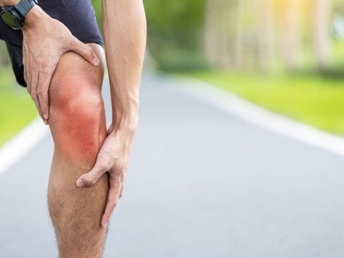 Scopri cos'è la tendinite! Uomo si tocca il ginocchio dolorante