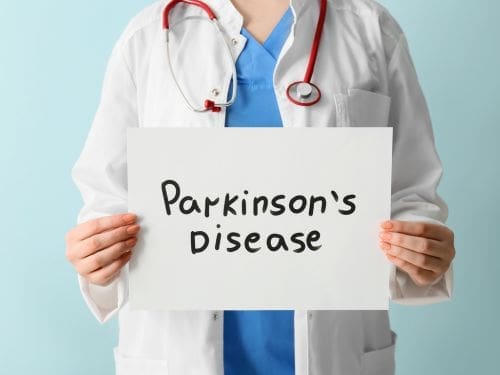 Illustrazione di un medico che mantiene un foglio con scritto "Parkinson's Disease"